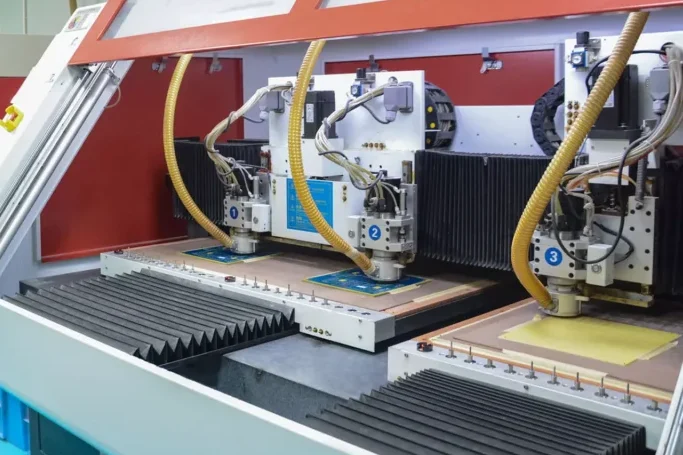 Macchina per l'inserimento automatico di PCB con bracci robotici che inseriscono componenti elettronici passanti per l'assemblaggio elettronico automatizzato